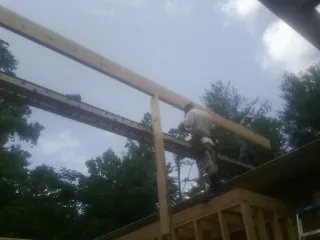 Carpenter setting a ridge beam over a new addition frame — Ice Dam Removal by Roofing Brothers in Grand Ronde