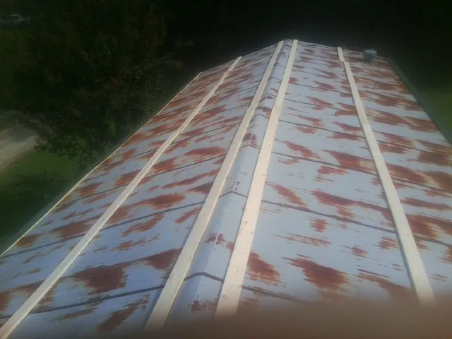 Rusted metal roof panels with new wood purlins before replacement in Grand Ronde