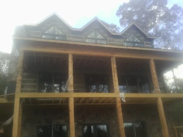 Dormers and porch framing on a large log home under construction — Roof Coating work by our crew in Grand Ronde